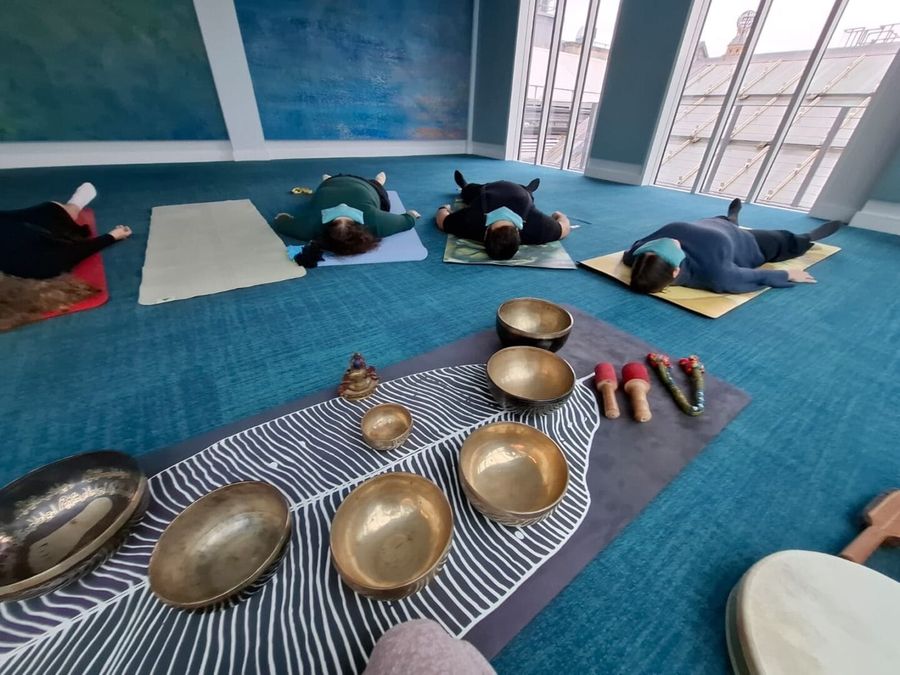 A team lying back during a live workplace sound bath